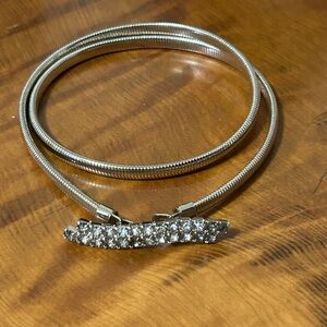 Silver-tone coil stretch cinch belt with a rhinestone buckle